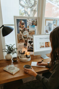 Woman writing list at desk.