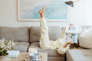 Woman reading magazine on couch.