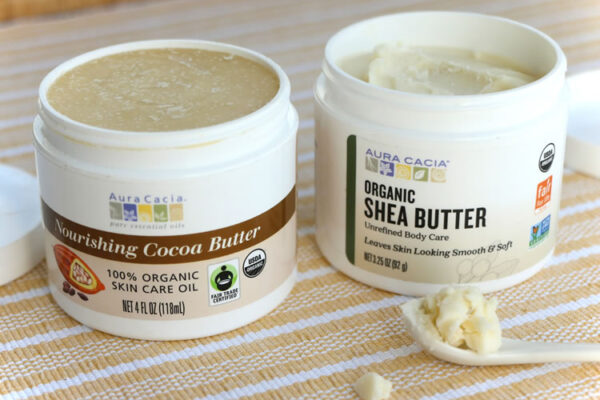 Jar of Aura Cacia Organic Shea Butter next to cocoa butter, ingredients for DIY citrus mint body butter recipe