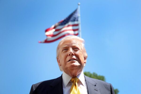U.S. President Donald Trump speaks in front of the American flag to the press as he departs the White House on May 12, 2026 in Washington, DC.