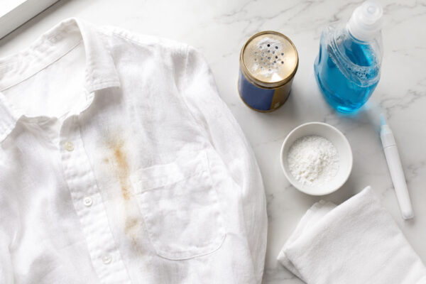 a white linen shirt with an orange sunscreen stain. cleaning supplies trying to remove it.
