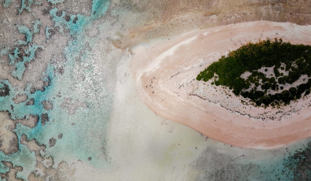 An aerial view as vegetation regrows on an islet (R) where trees were obliterated by a past storm in the Funafuti atoll on November 26, 2019 in Funafuti, Tuvalu.