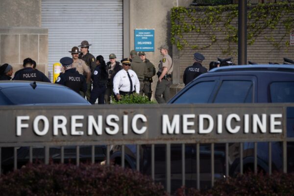 Police officers gather outside of the county morgue as the remains of a fellow officer who was fatally shot in the line of duty arrive from the hospital on April 25, 2026 in Chicago, Illinois.