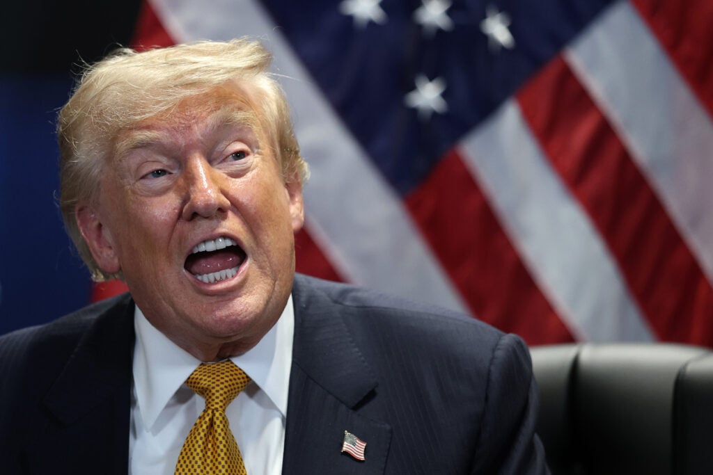 Donald Trump speaks, mouth wide open.